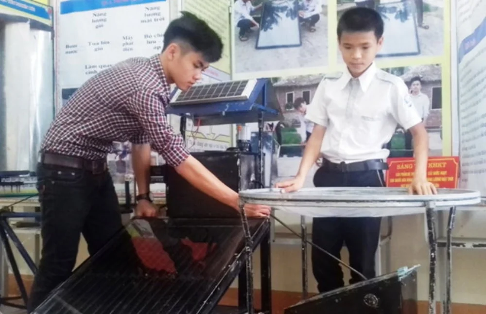 Ngô Thành Đạt (trái) và Nguyễn Tiến Dũng giới thiệu chiếc máy biến nước mặn thành nước ngọt -Ảnh: D.HÒA