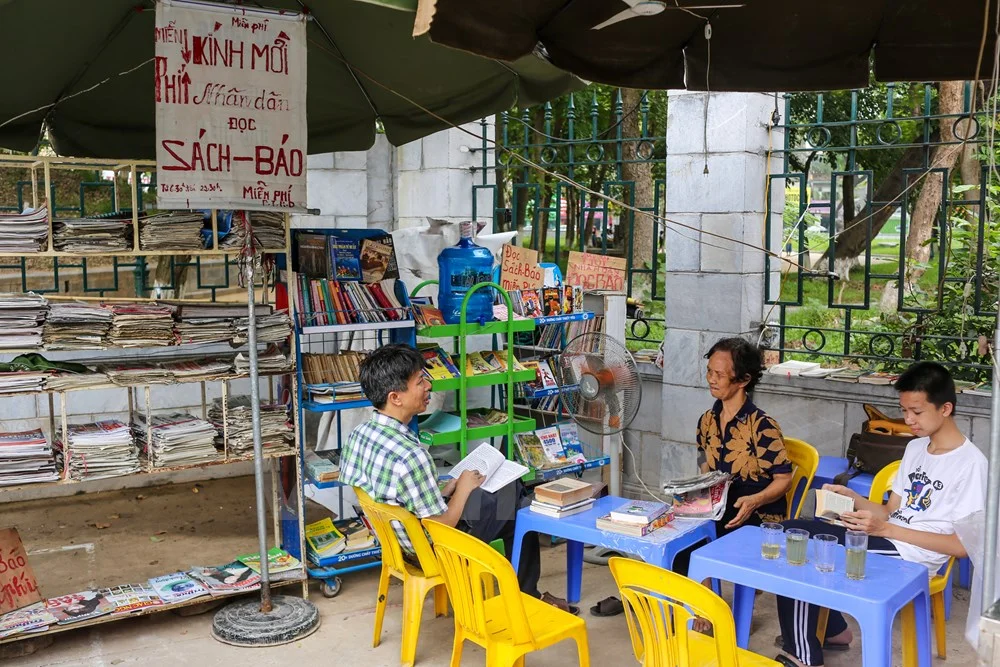 Bắt đầu được gần 5 tháng, quầy báo miễn phí của bà Phạm Thị Huyền Dung, 72 tuổi (trú tại Đặng Tiến Đông, Hà Nội) đã thu hút nhiều người dân Thủ đô tìm đến. (Ảnh: Minh Sơn/Vietnam)