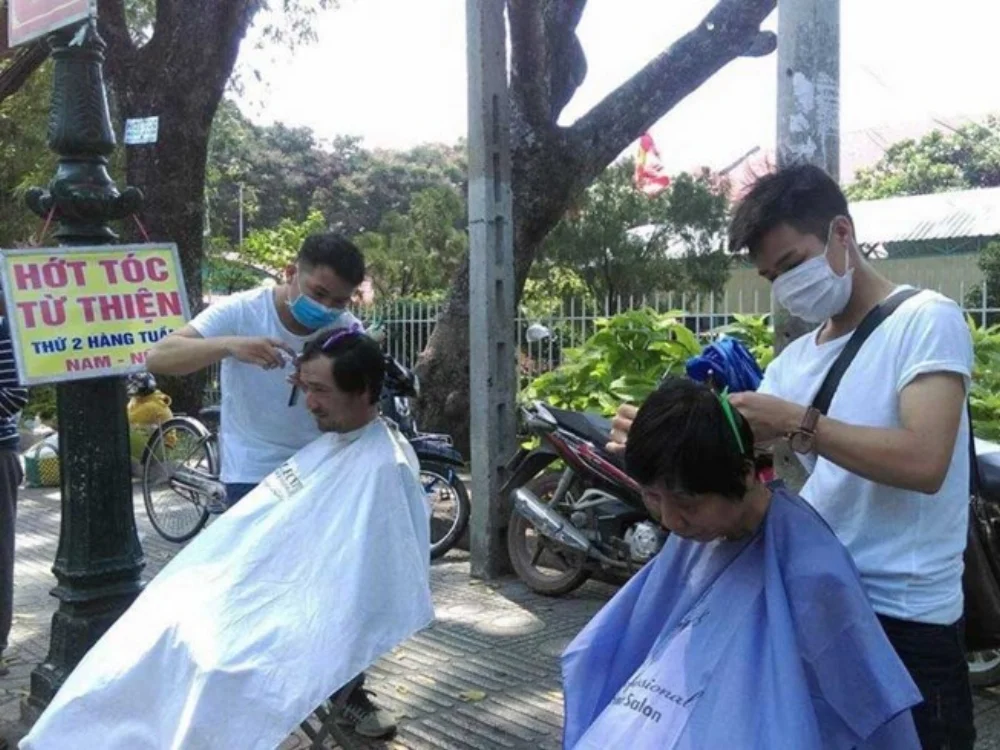Mỗi thứ Hai hằng tuần, anh Tân (bìa trái) lại cùng đồng nghiệp lên Sài Gòn hớt tóc miễn phí cho người nghèo. Ảnh: MINH TÂM