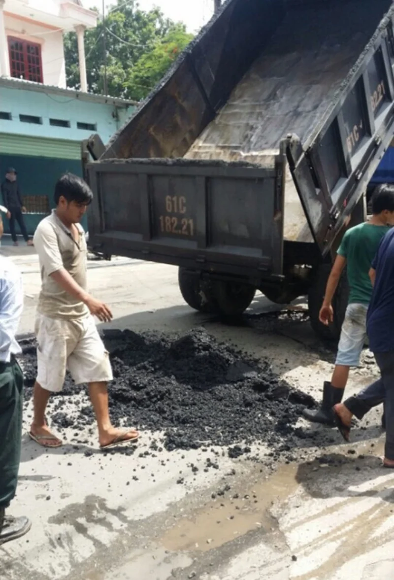 Xe ben đổ nhựa xuống lỗ trũng - Ảnh: Người dân cung cấp