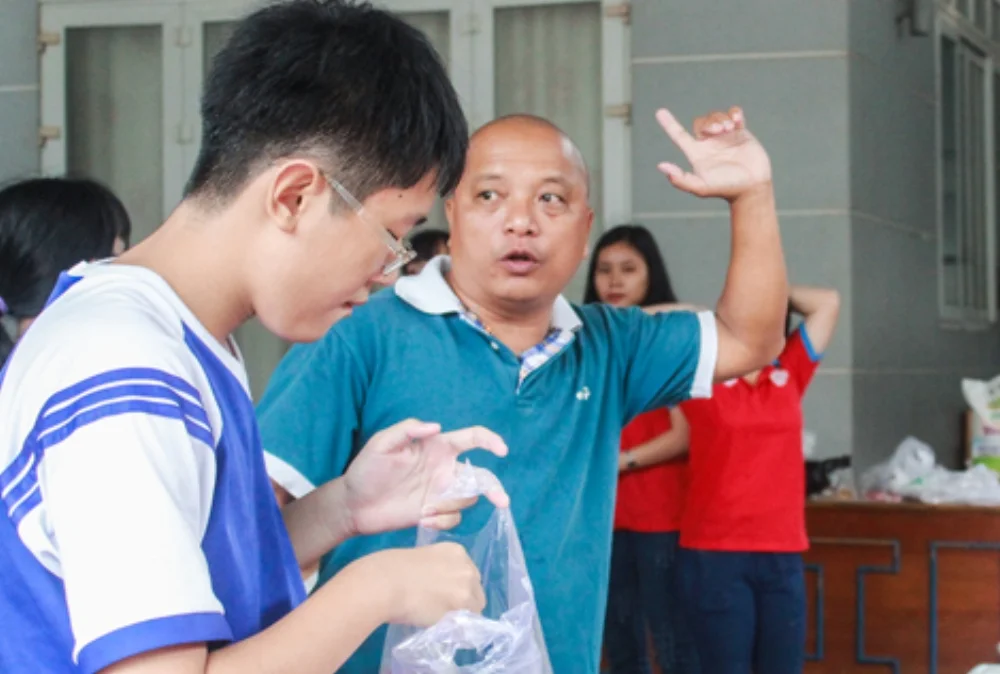 Ông Tài đốc thúc mọi người chuẩn bị bữa ăn trưa cho thí sinh. Ảnh: Thảo Ly.
