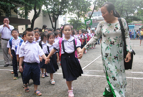 Học sinh lớp một trường Tiểu học Nguyễn Trọng Tuyển, thành phố Hồ Chí Minh được cô giáo dẫn vào lớp (ảnh Mạnh Tùng - Vnexpress)