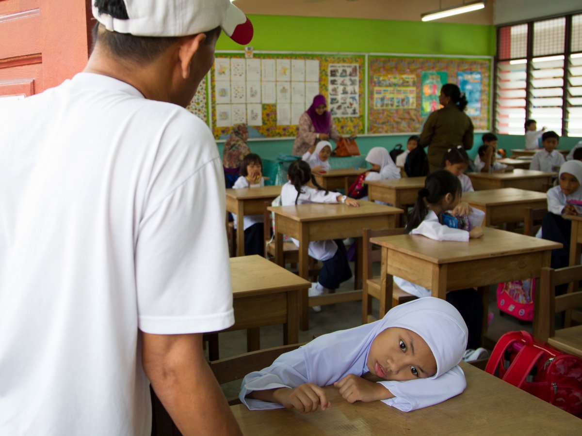 Một em nhỏ Malaysia cảm thấy mệt trong ngày đầu tiên đi học (nguồn: AP Photo/Lim Huey Teng)