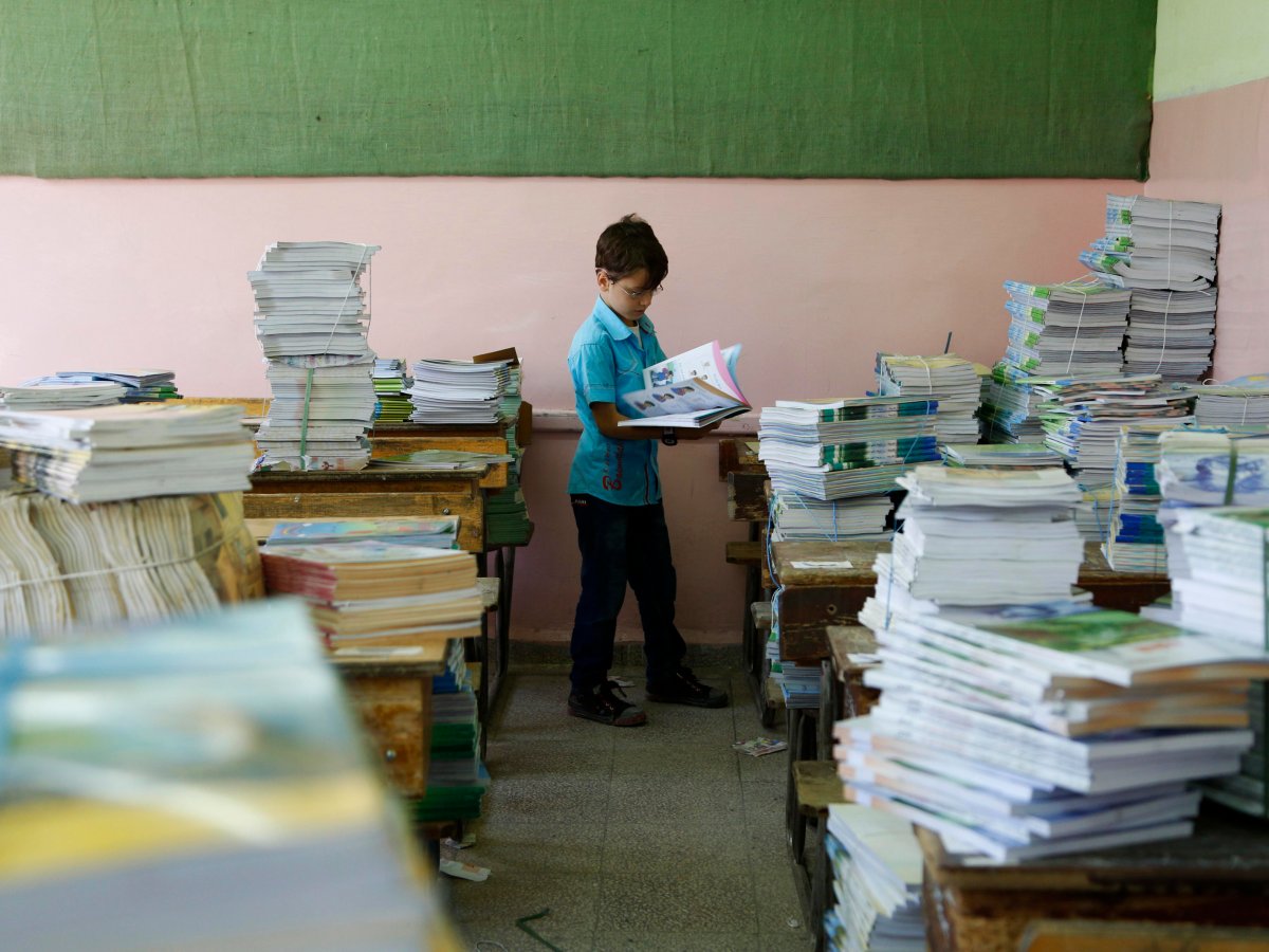 Một em nhỏ Syria nhận sách tại trường (nguồn: REUTERS/Omar Sanadiki)
