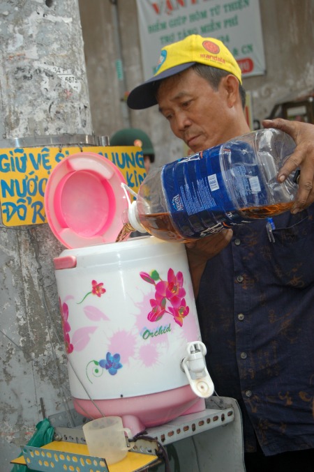  Bên cạnh tủ thuốc, bình nước trà đá miễn phí được nhiều người đi đường thường xuyên sử dụng. Bình nước do ông Đỗ Văn Út (sinh năm 1963) phụ trách pha trà, thêm đá... từ mấy chục năm nay. Ông Út được bà con trong hẻm ví là "cây từ thiện" bởi đã khởi 