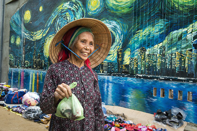  Một phụ nữ địa phương đi chợ ngang qua phố thị - Ảnh: LÊ HỒNG LINH 