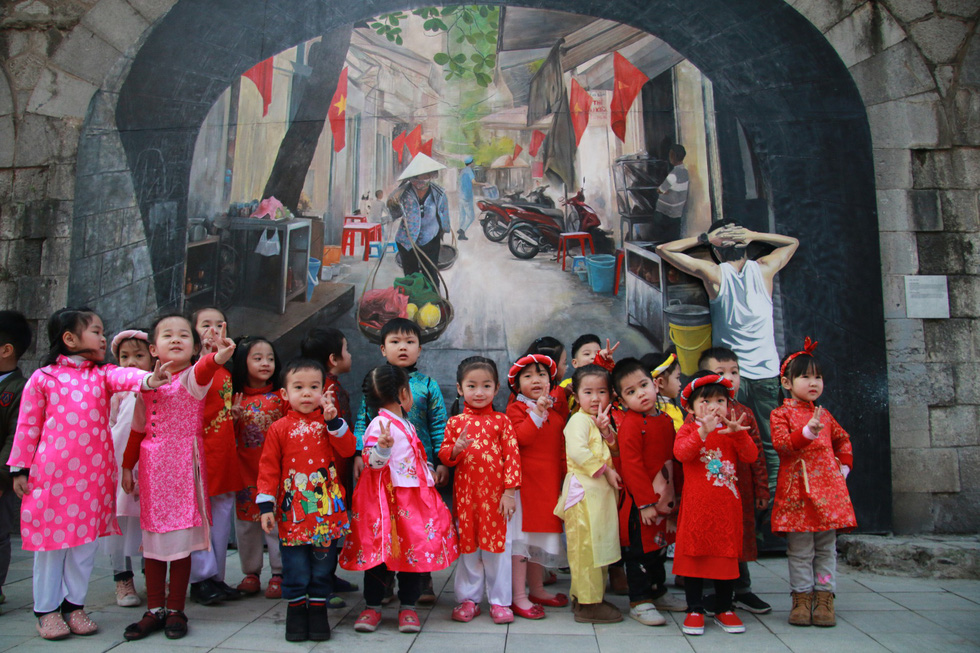  Các bé được cô giáo dẫn đến phố bích họa Phùng Hưng chụp ảnh lưu niệm - Ảnh: DANH TRỌNG 
