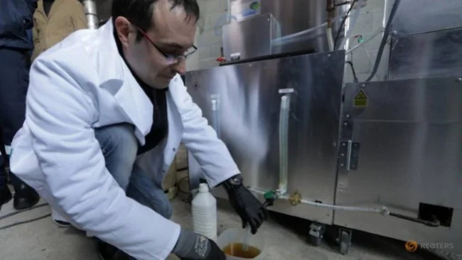 Christofer Costes đang “đón” những giọt nhiên liệu được ép từ rác thải nhựa.