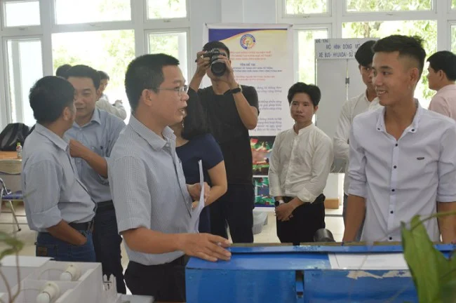 Nguyễn Văn Bảo (ngoài cùng bên phải) bên chiếc máy gieo hạt lạc. Ảnh: Nhật Tuấn