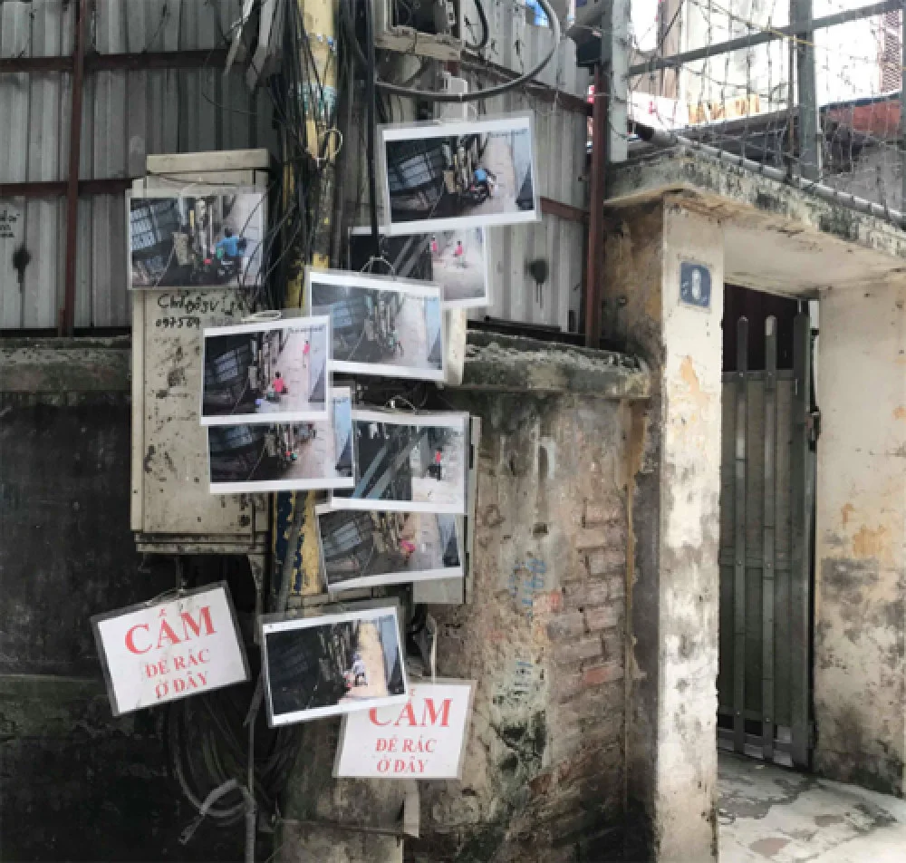Gần chục bức hình người đổ rác trộm treo trên cây cột điện, tuy không rõ mặt nhưng khiến nhiều người e ngại không dám tái phạm. Ảnh: Lệnh Thắng.