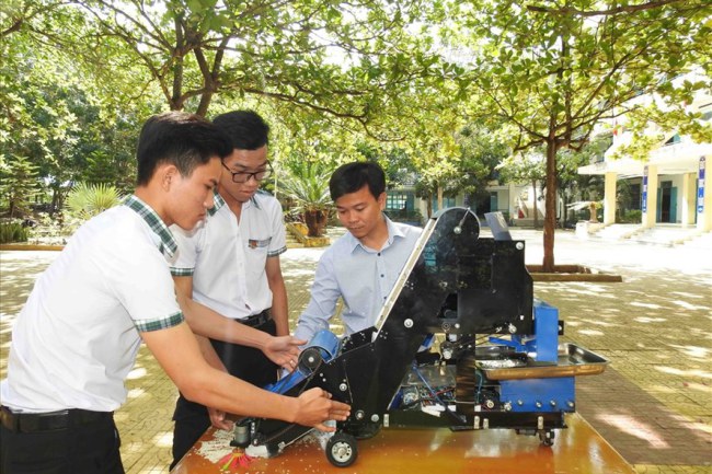 Thầy trò Nguyễn Hữu Thực và Trần Hoàng Nguyên bên sản phẩm đoạt giải Nhất cuộc thi Khoa học kỹ thuật cấp quốc gia học sinh THPT năm học 2018-2019 do Bộ Giáo dục và Đào tạo tổ chức. Ảnh: P.V