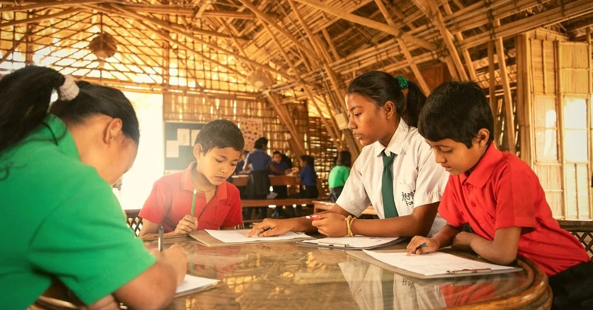 Các học sinh lớn dạy kèm các em nhỏ hơn.