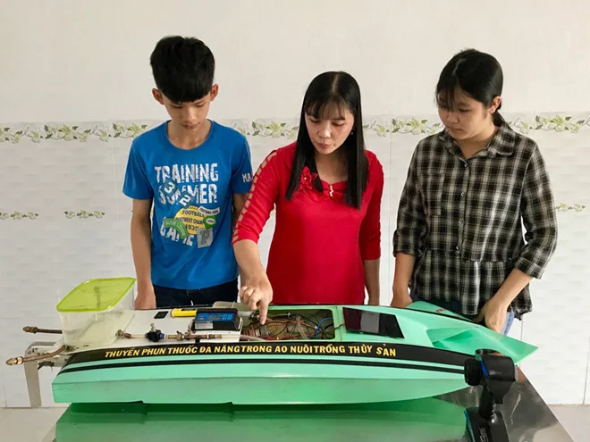 Cô giáo hướng dẫn và hai học sinh sáng chế thuyền phun.