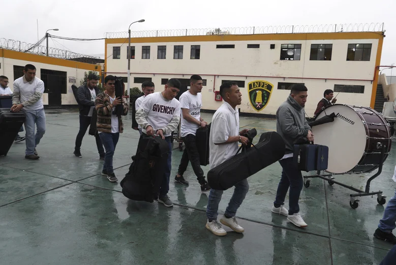Những phạm nhân này cầm nhạc cụ trong trạng thái tay vẫn bị còng, khi di chuyển đến nhà hát.