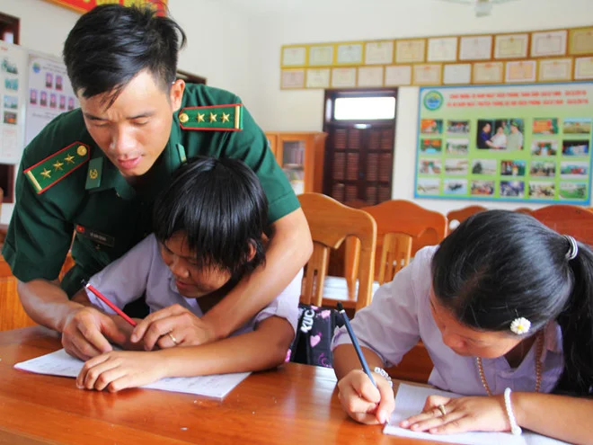 Thượng úy Lê Văn Chính hướng dẫn học sinh viết chữ.