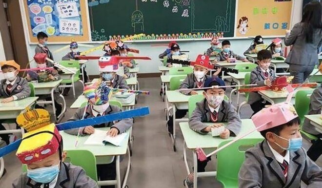  Trước đó, hồi cuối tháng 4, một trường tiểu học ở thành phố Hàng Châu cũng đưa ra cách cho học sinh đội những chiếc mũ giãn cách cỡ lớn. Học sinh tự trang trí mũ với màu sắc, hình dán, bông hoa, cây lá tùy thích, rồi gắn thêm thanh dài 1 m. Ngoài ra