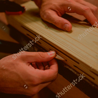 stock-photo-carpenter-working-on-his-craft-in-a-dusty-workshop-419362018-SQUARE.jpg