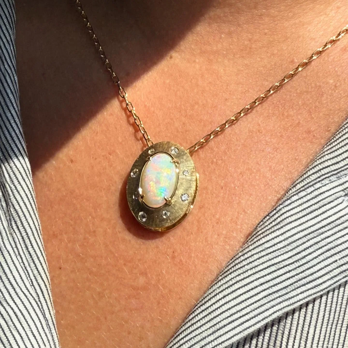 Opal, the birthstone for October.  Known and sought after for its beauty, rarity, and play of color with flashes of light.

This stunning family heirloom opal is the focal point of this custom design 18k yellow gold pendant accented with diamonds.