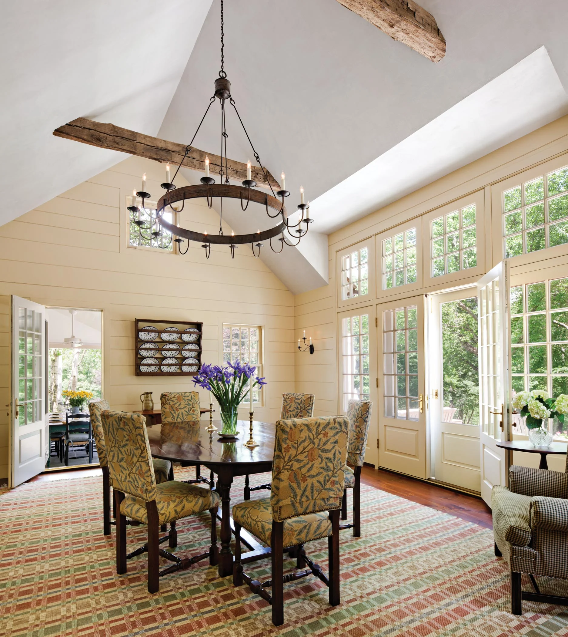 The sunny Breakfast Room features a custom French door assembly and a massive tin chandelier.
