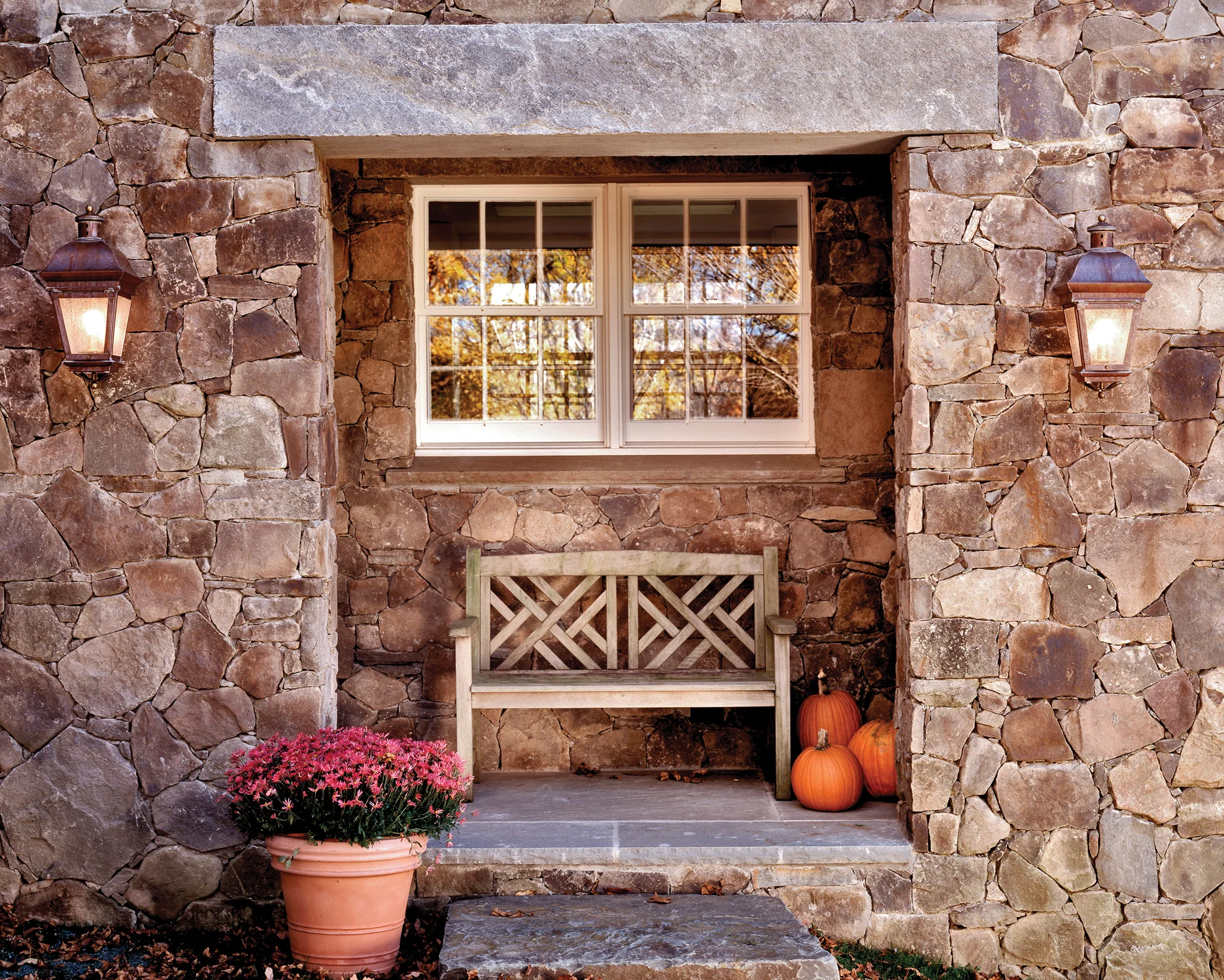 A fieldstone porch with a massive granite lintel leads to the lower level Mud Room.