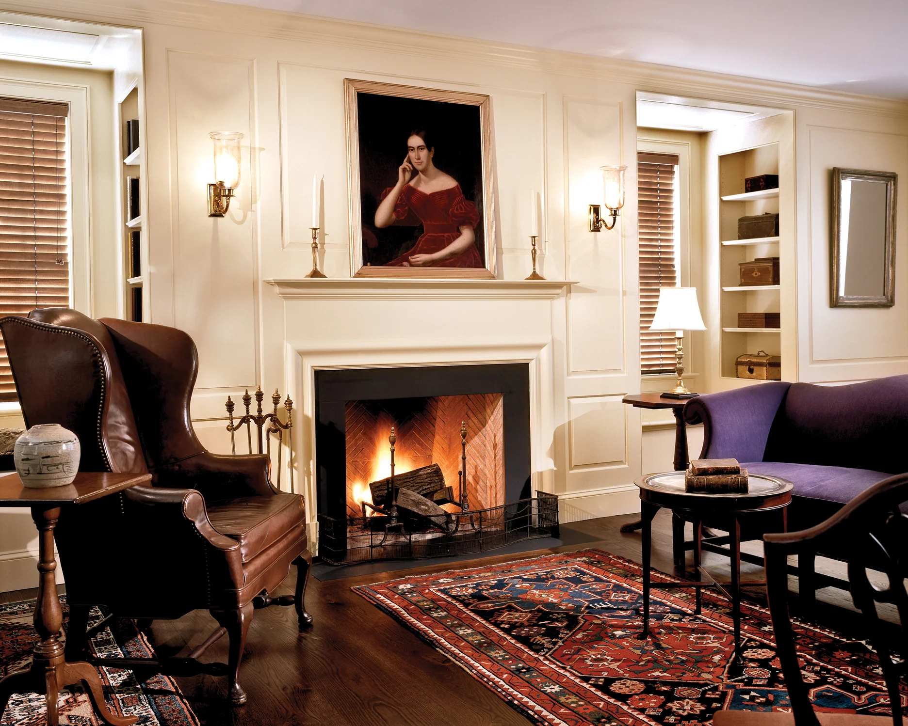 The paneled fireplace wall of the Living Room features windowseats with built-in shelving.