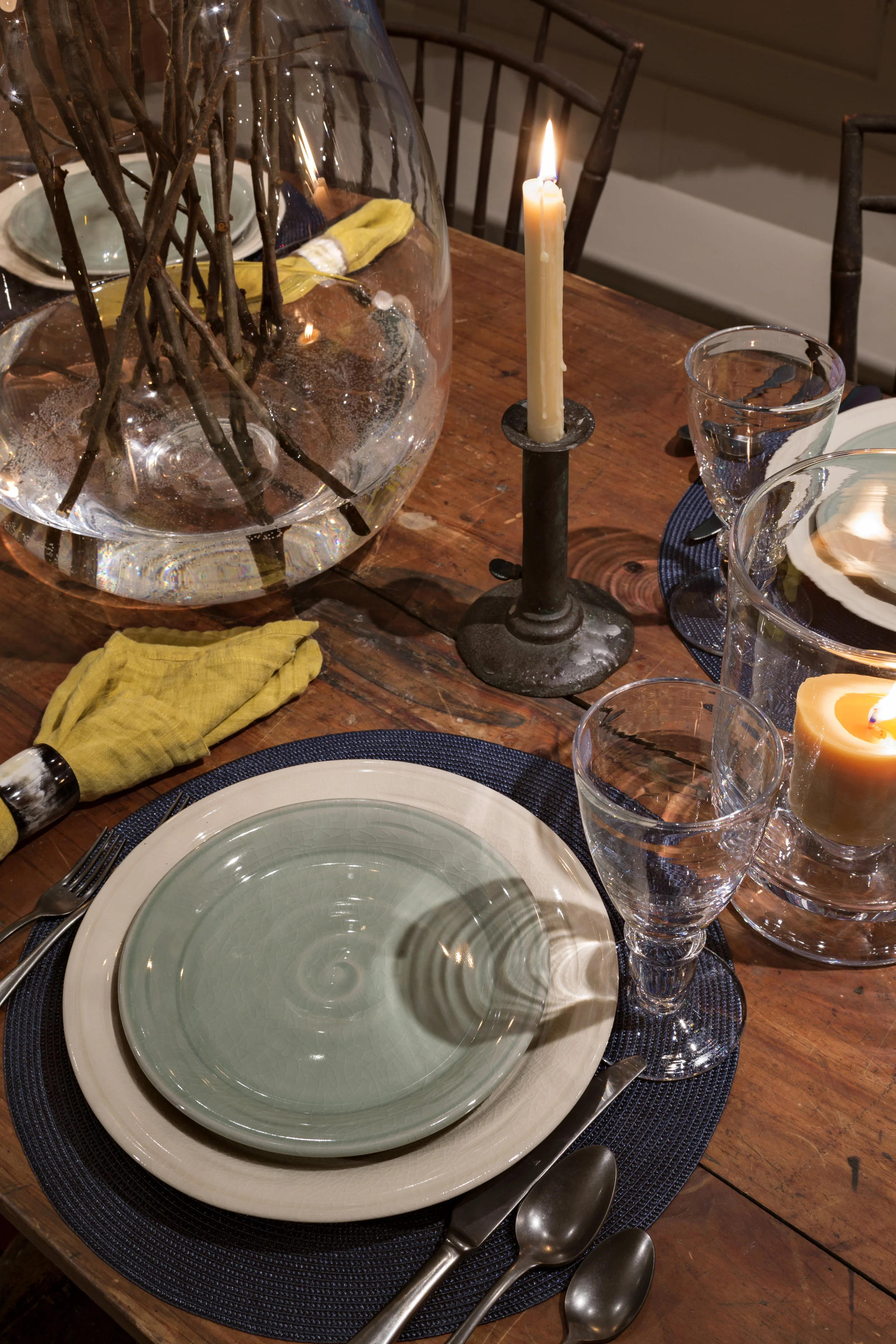 Table Setting. Colorful Simon Pearce accessories complement the rustic antique sawbuck table.