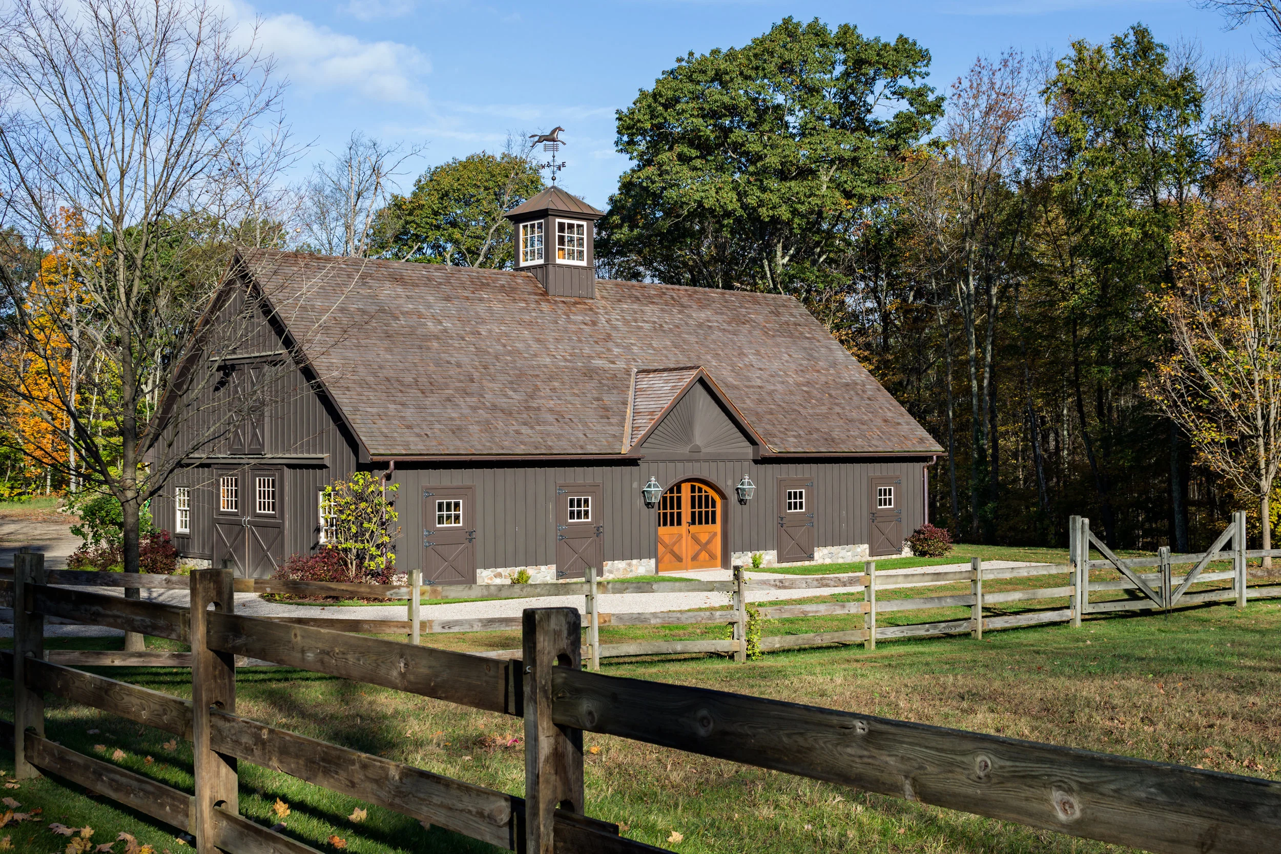 The addition of a central cupola and a wood roof distinguish the large stable.