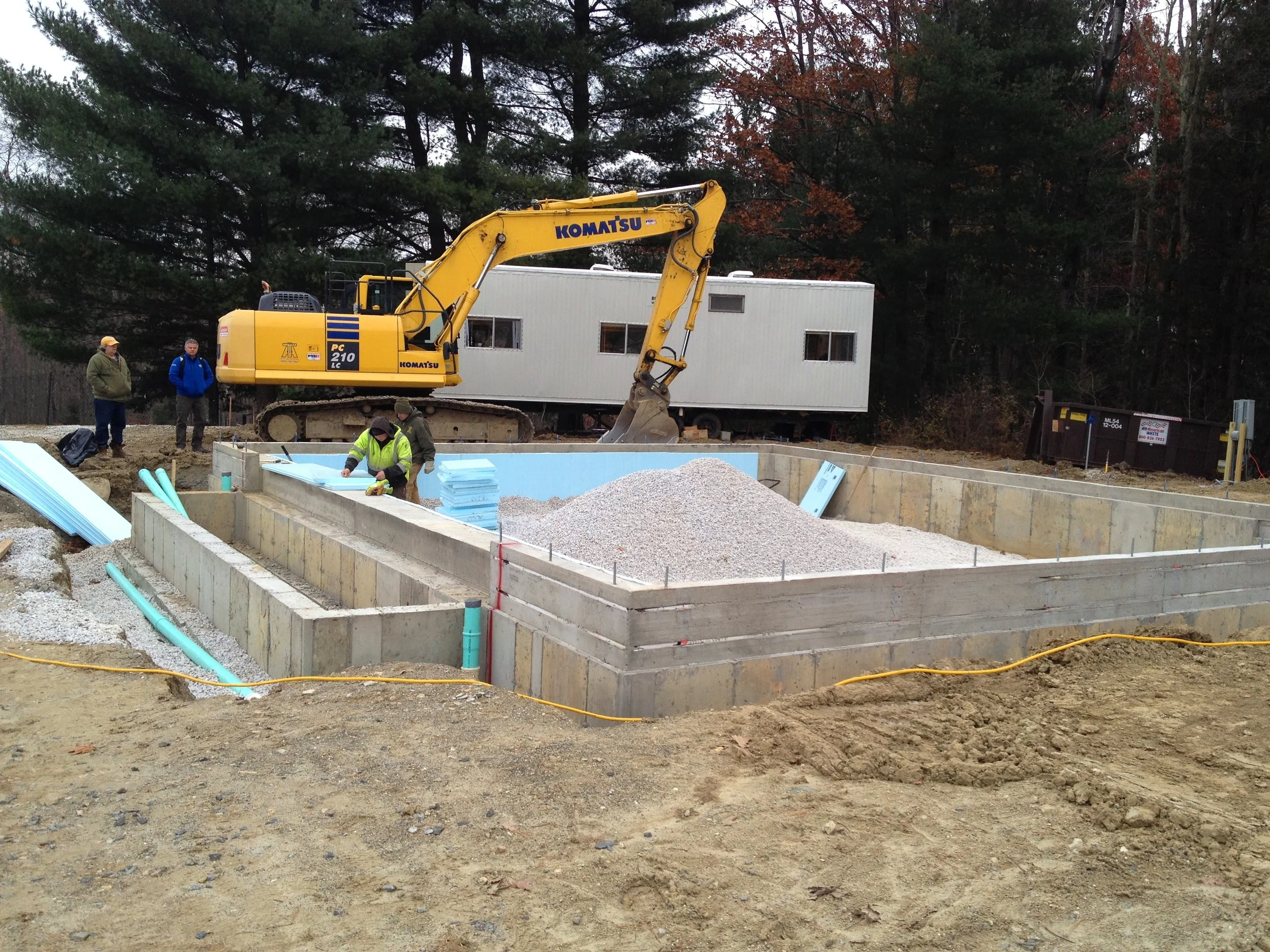  Workmen insulate the newly poured foundation of the pool house. 