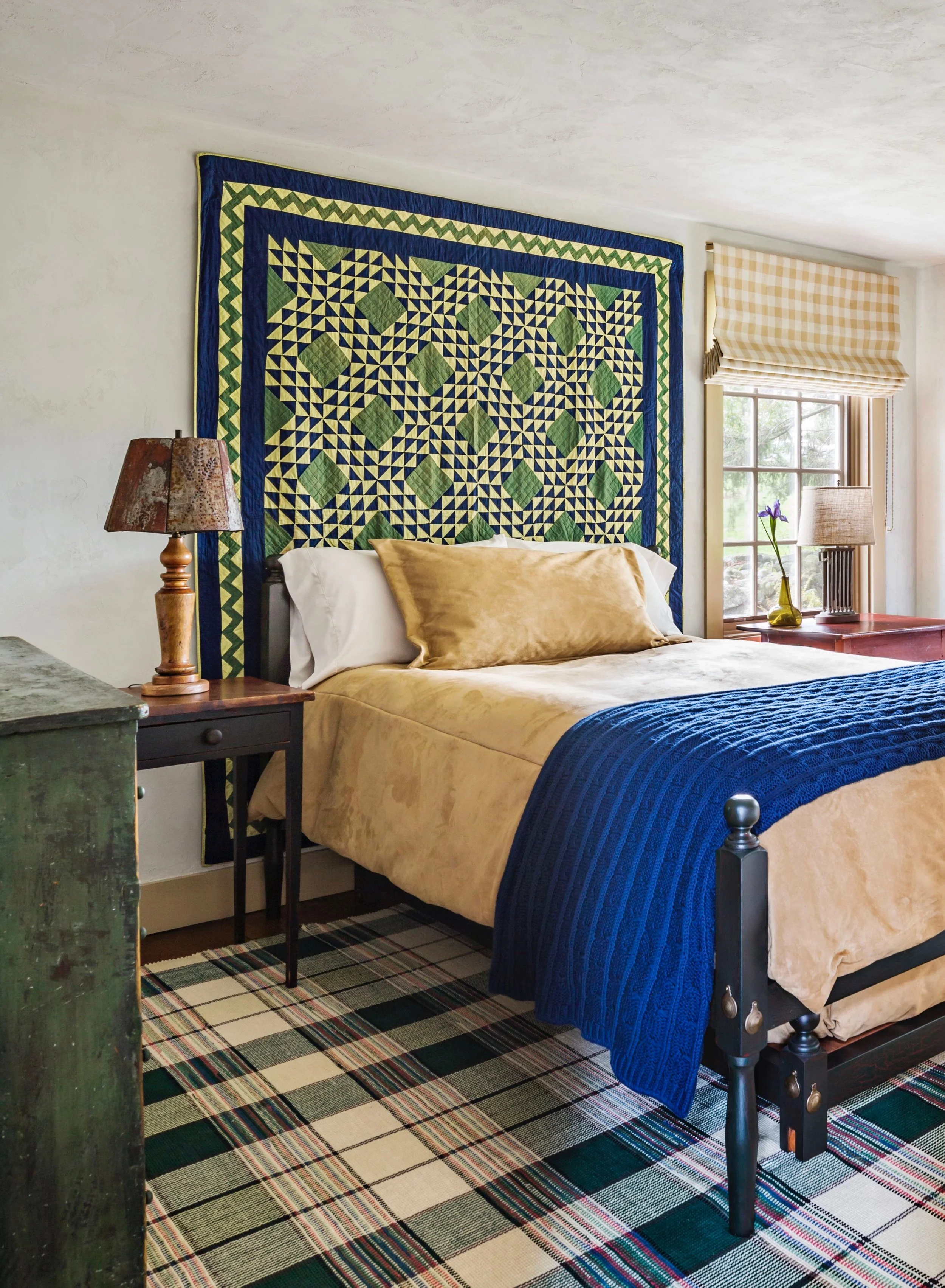 A bold 19th century Amish quilt provides a distinctive backdrop for this guest bedroom.
