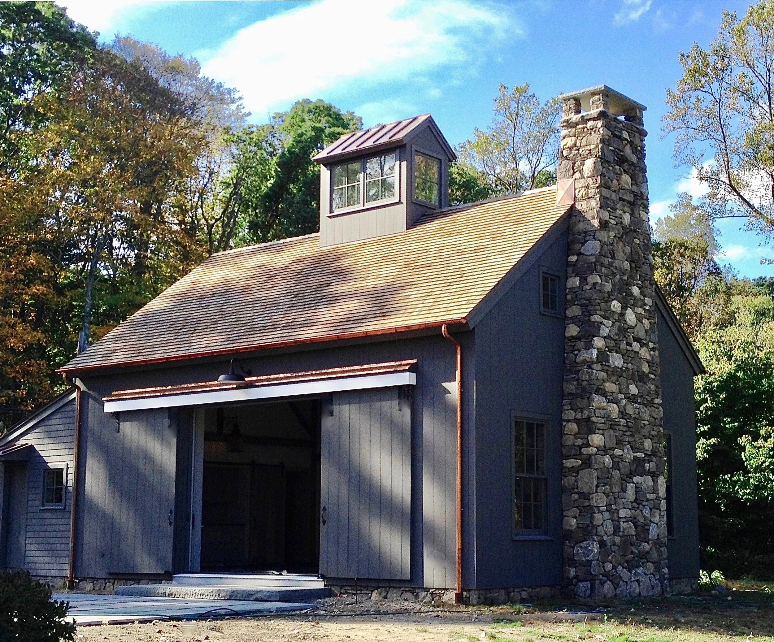 A deep grey stain was selected to complement the stone chimney & cedar roof.