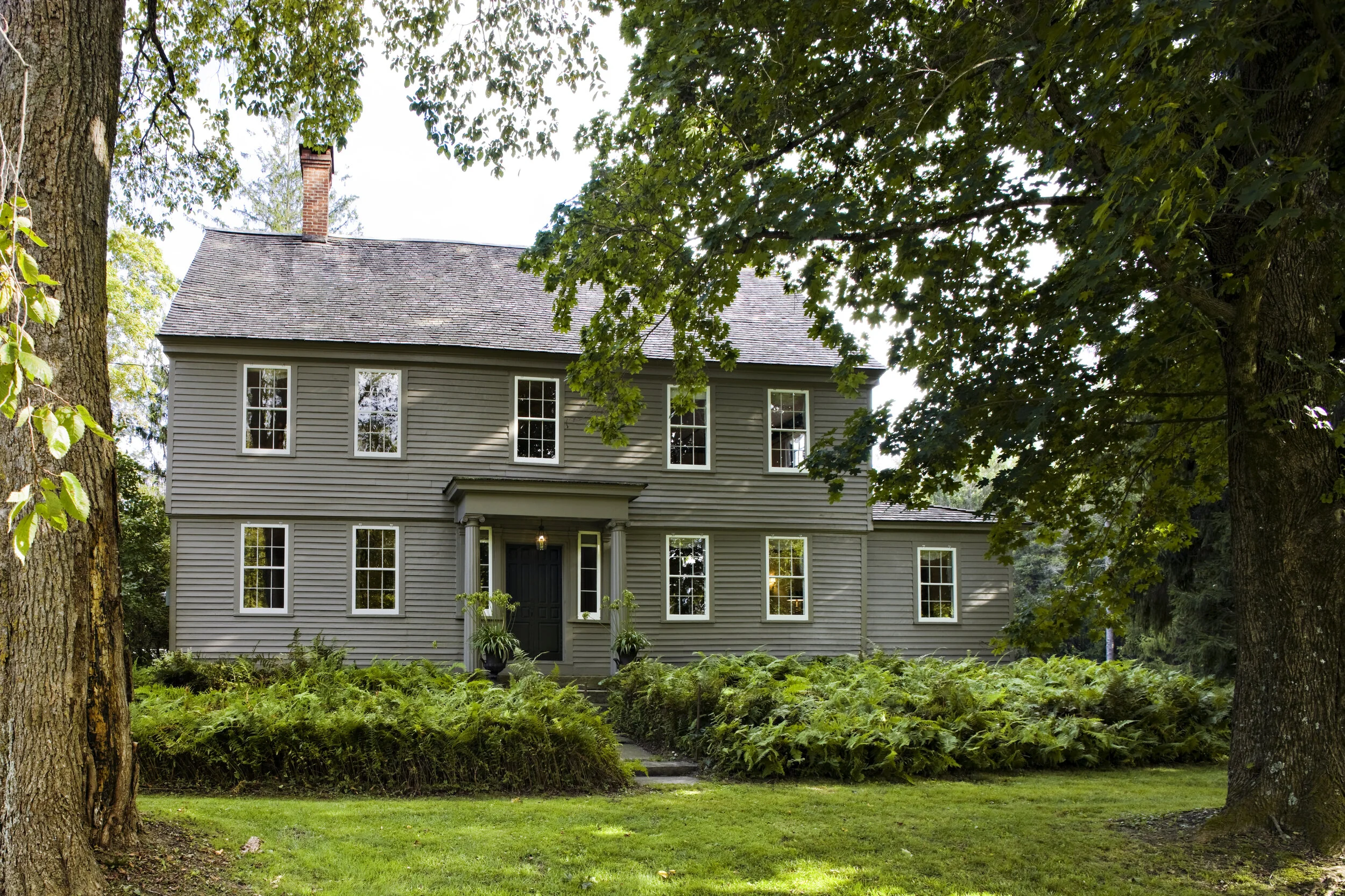 The restored entrance facade features a neoclassical portico with fluted ionic columns.