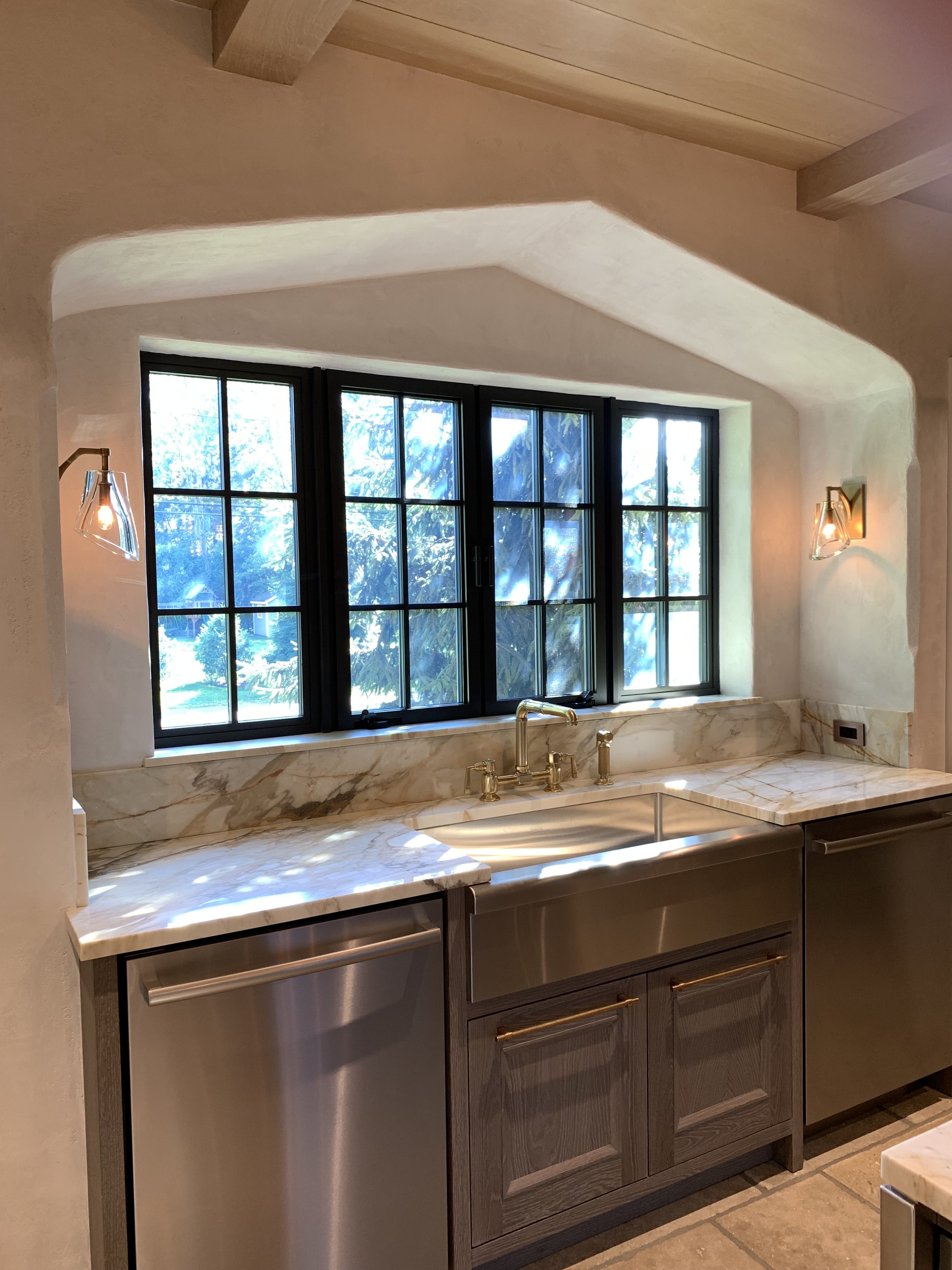 The deep Tudor arch above the sink recalls the detailing of the original house.
