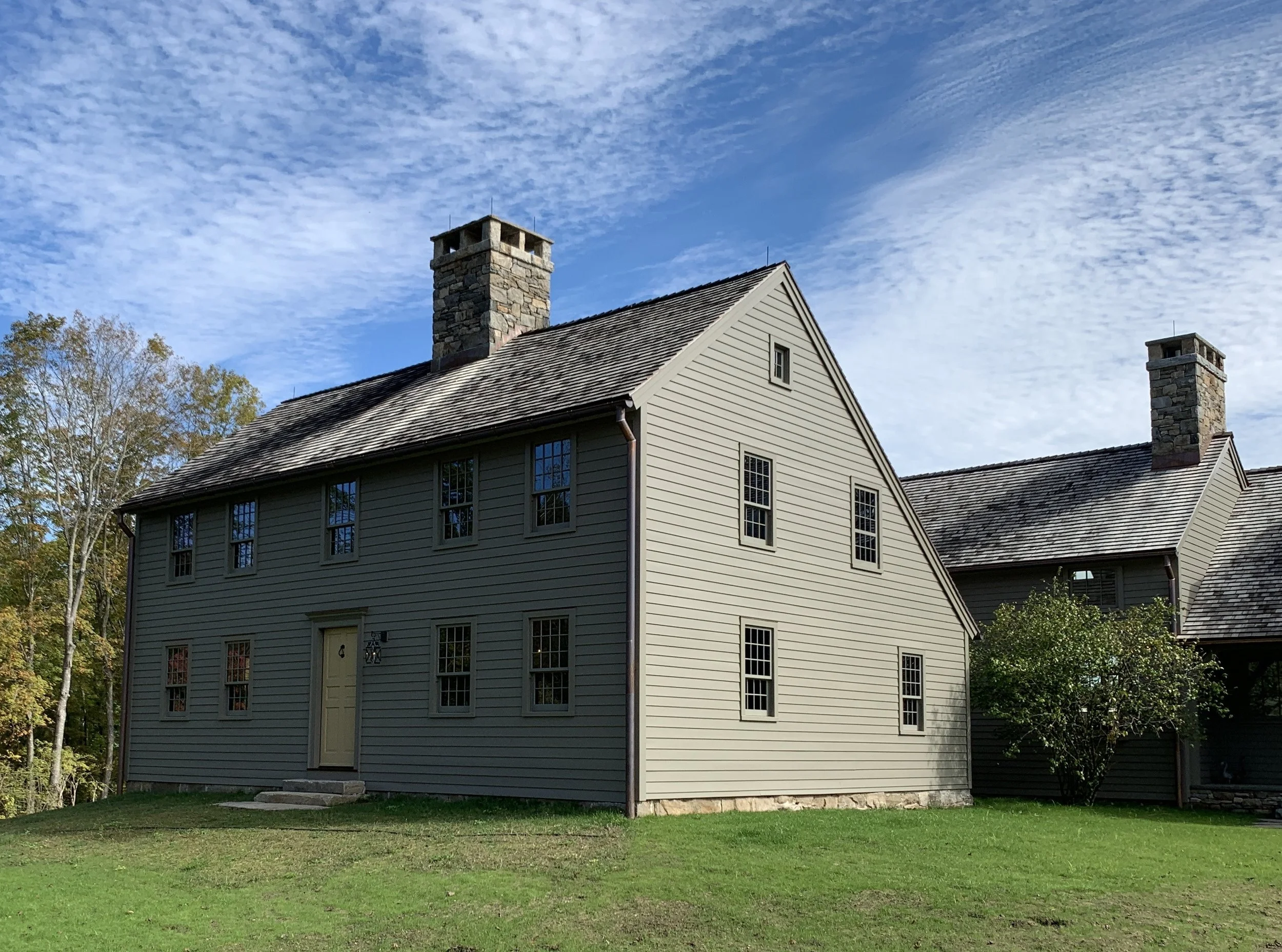 The deep grey paint accentuates the primitive quality of the original saltbox.