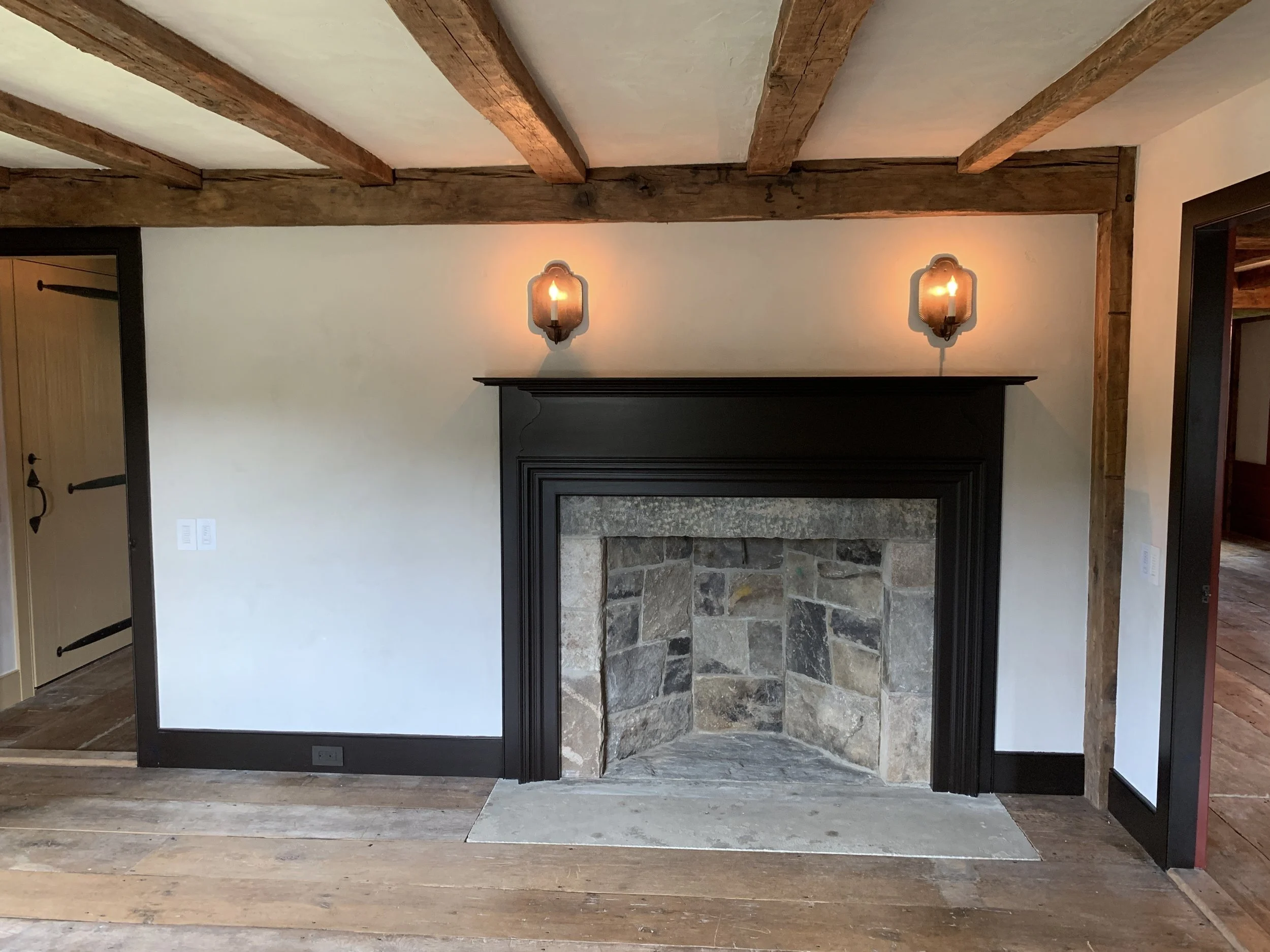 The Tavern Room’s deep brown trim contrasts the unpainted rough plaster walls.