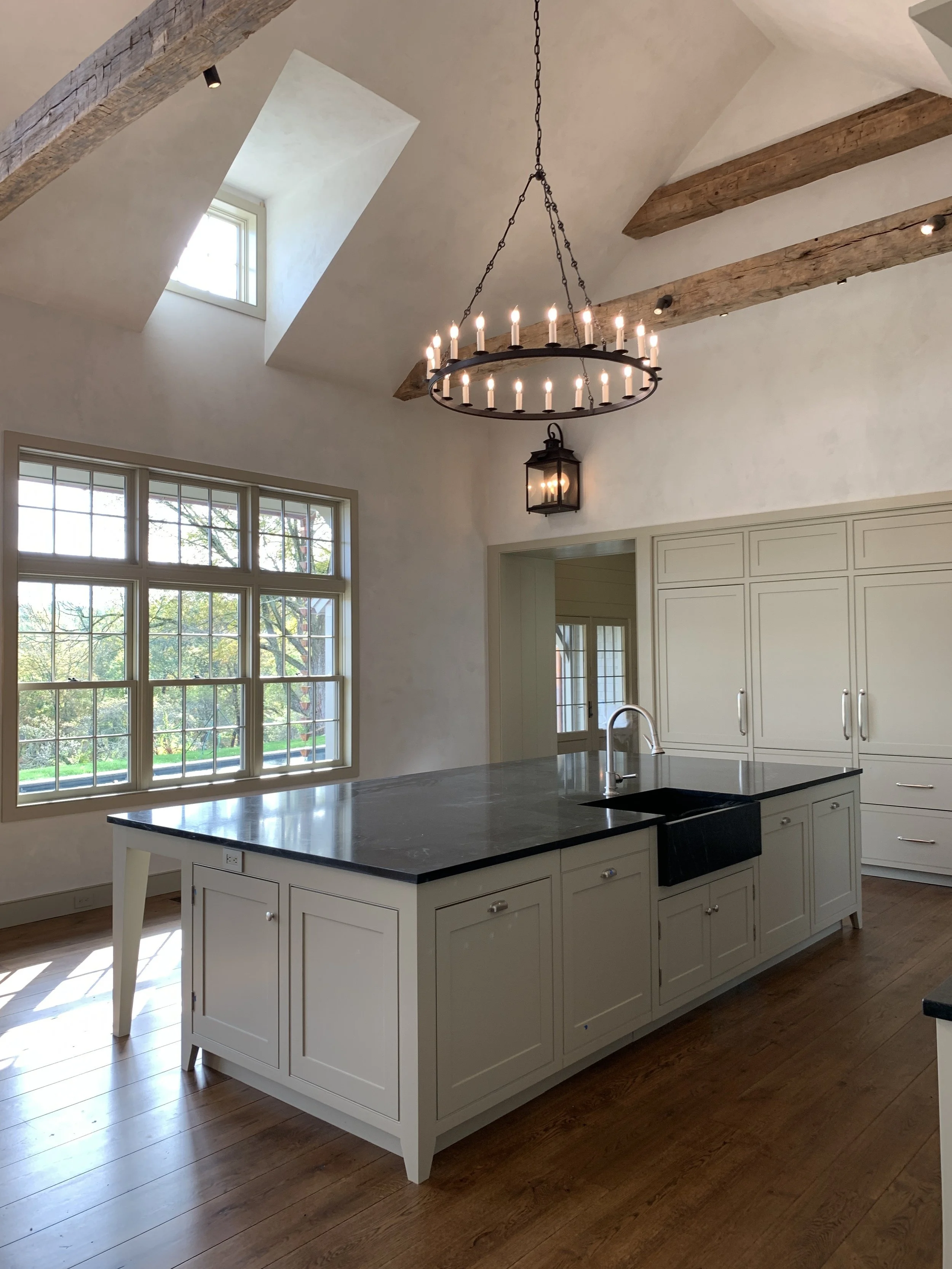 The Kitchen Island features a soapstone top with an integral custom farm sink.