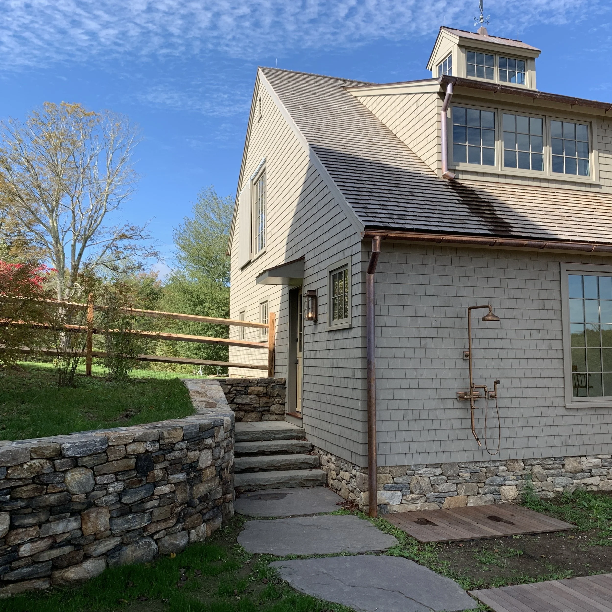 A copper outdoor shower serves the pool deck.
