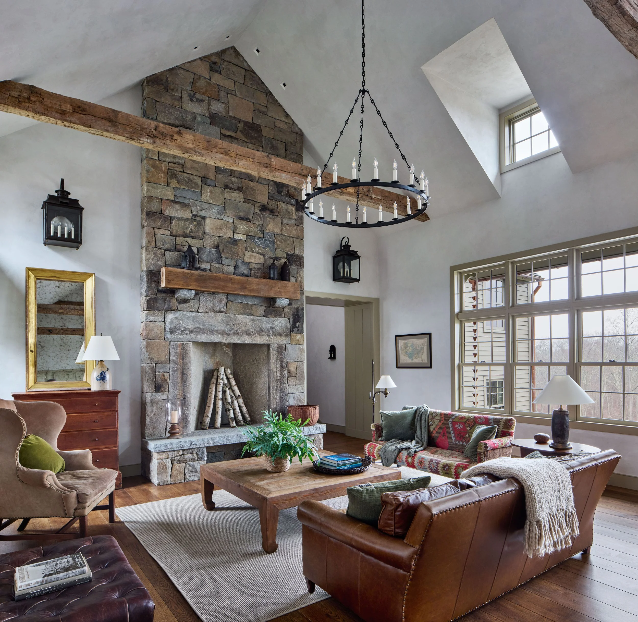  Locally sourced antique stones form the surround of the Great Room’s fieldstone fireplace.&nbsp; A series of dormers flood the room with morning light. 