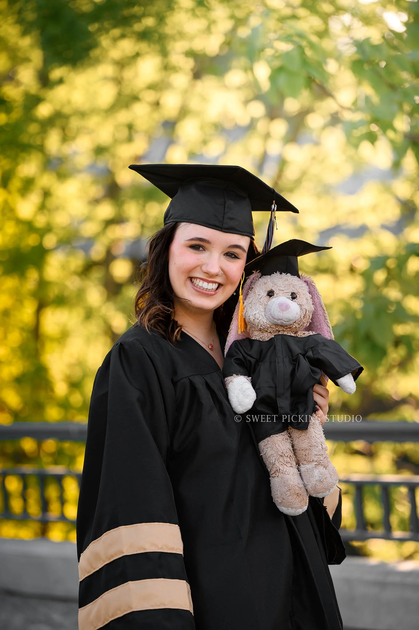 Hailee | Noblesville High School Graduation Photography in Cap and Gown in Downtown Nature location for class of 2026 senior girl with stuffed animal by Sweet Pickins Studio senior photographer Amanda Wilson ©