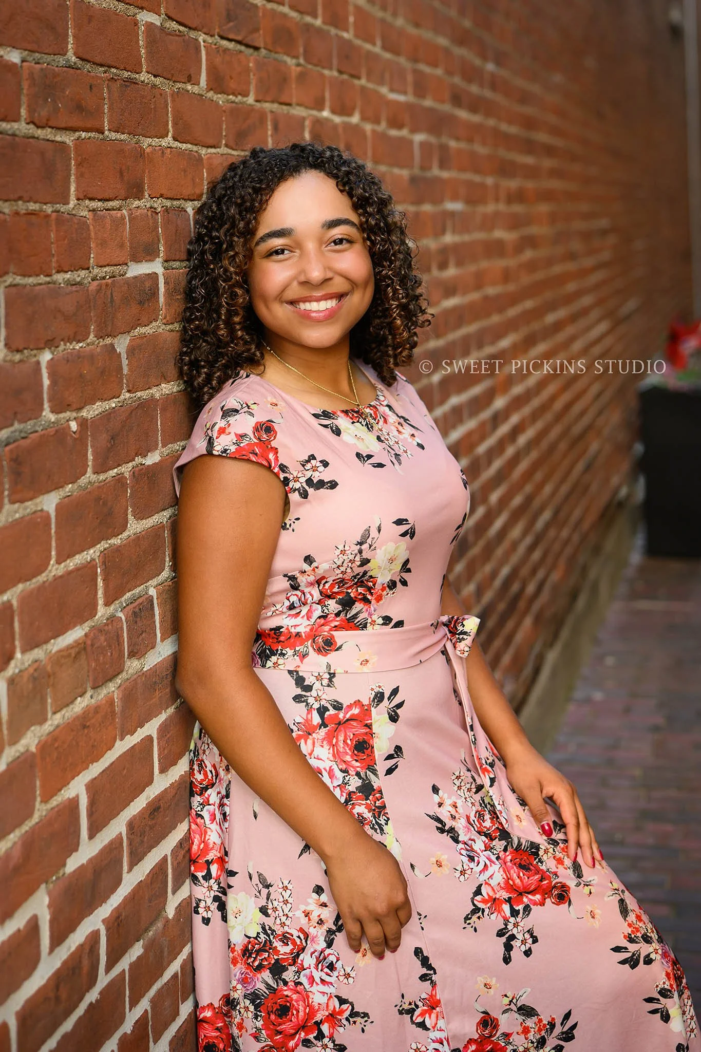 Piercey ‘s Peru, Indiana Senior Photography in pink floral dress for Class of 2027 senior girl in downtown urban alley by Sweet Pickins Studio senior photographer Amanda Wilson ©