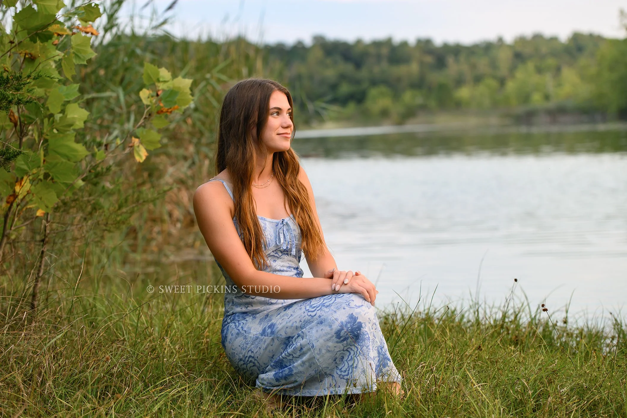Taylor | Indiana Senior Girl Photography for class of 2027 senior by lake at sunset wearing blue floral dress by Sweet Pickins Studio senior photographer Amanda Wilson ©