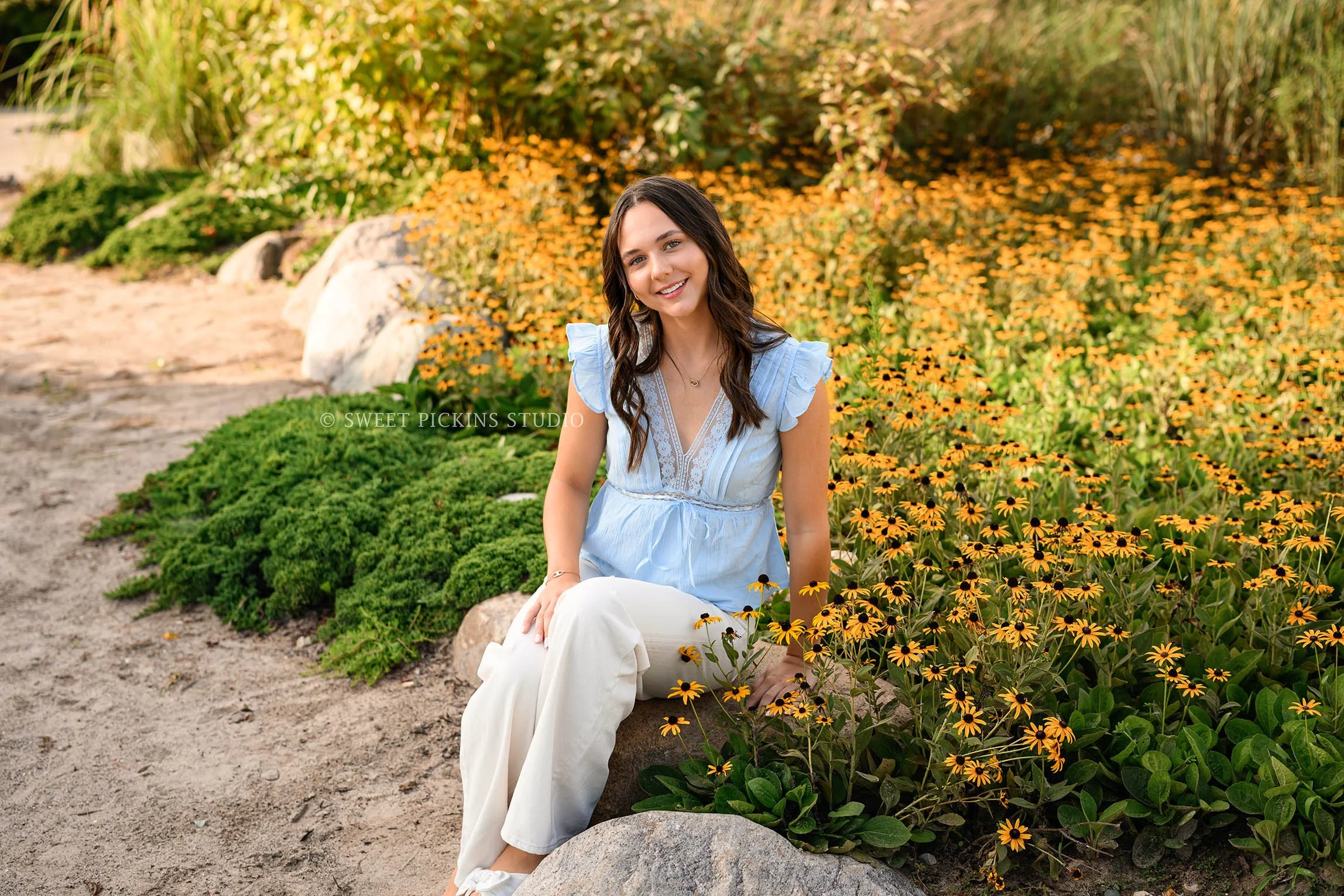 Sophie’s Carmel, Indiana Senior Portrait Photography by Sweet Pickins Studio senior photographer Amanda Wilson for class of 2027 Senior girl posing in blue eyelet top and white jeans in yellow flower ©