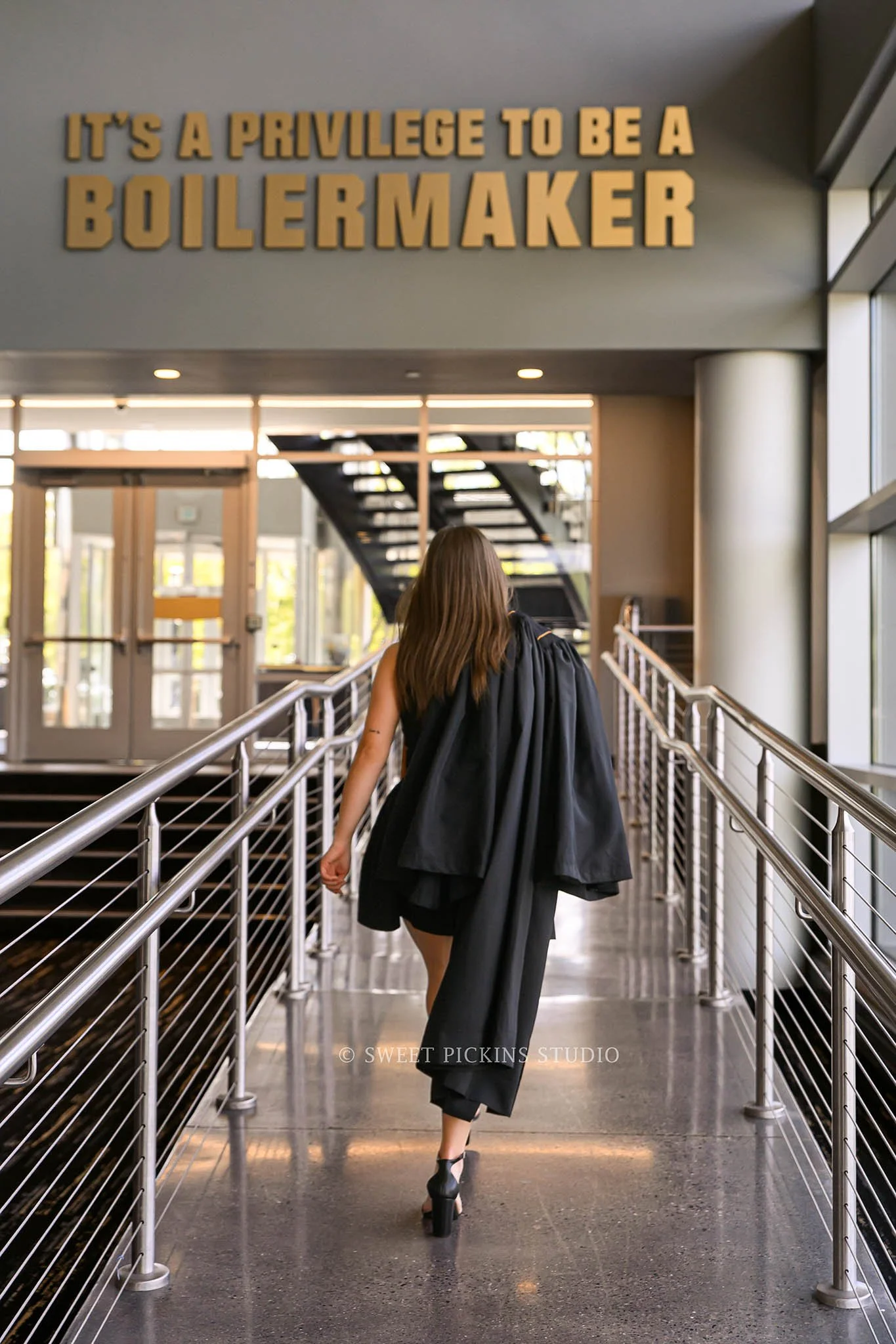 Ashelyn’s Purdue Boilermaker Graduation Portrait Photography at Mackey Arena for sports nutrition graduate wearing cap and gown in West Lafayette, Indiana by Sweet Pickins Studio senior photographer Amanda Wilson © 2026