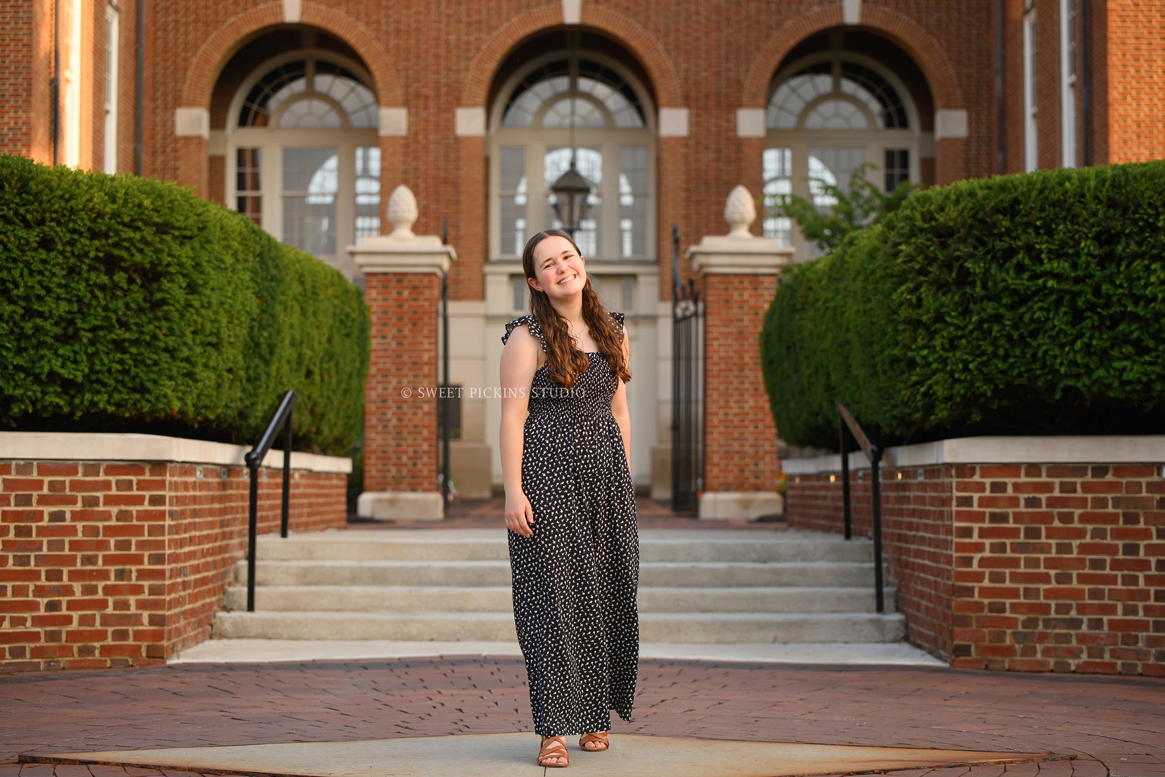 Downtown Carmel, Indiana Senior Photography for Class of 2027 Senior Ellen at city hall wearing floral romper in summer by Sweet Pickins Studio senior photographer Amanda Wilson ©