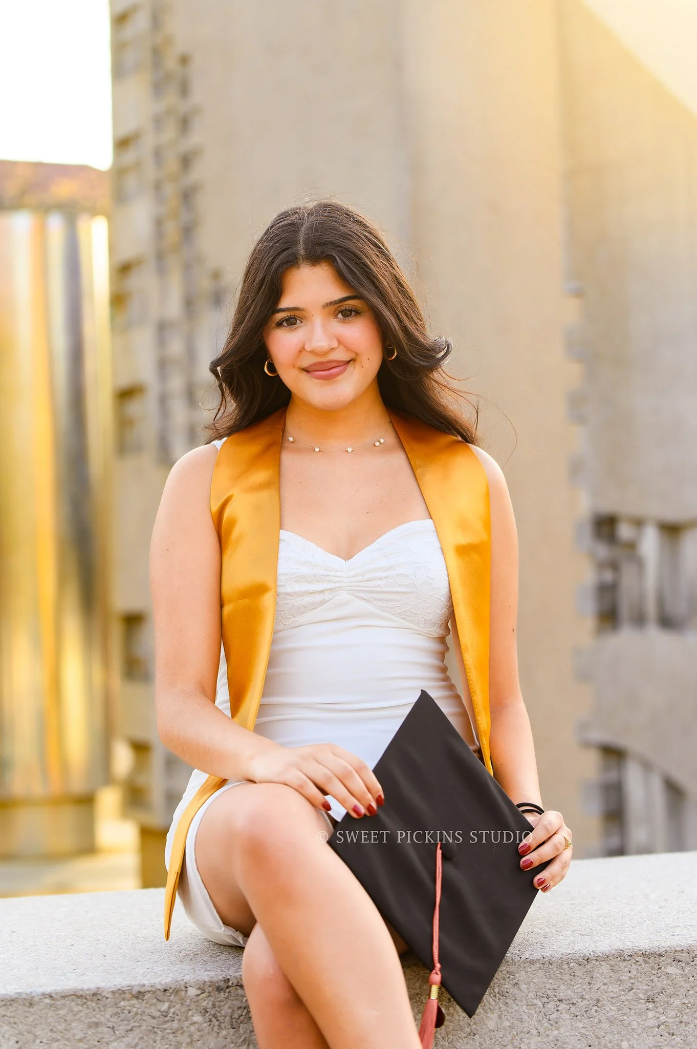 Maria’s Purdue University Graduation Portraits in West Lafayette, Indiana by Sweet Pickins Studio photographer Amanda Wilson for spring graduate posing in white dress at Hovde Hall with grad cap and tassel © 2026