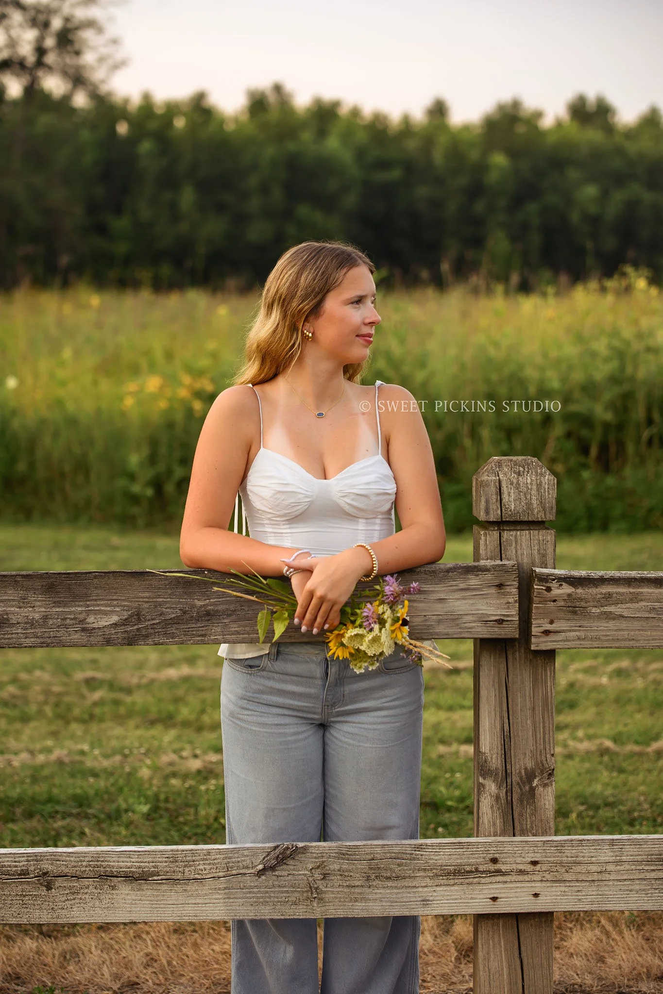 Kilyn’s Noblesville, Indiana Summer Senior Photography for class of 2027 senior girl wearing white tank and denim jeans in flower field location with bouquet by Sweet Pickins Studio senior photographer Amanda Wilson ©