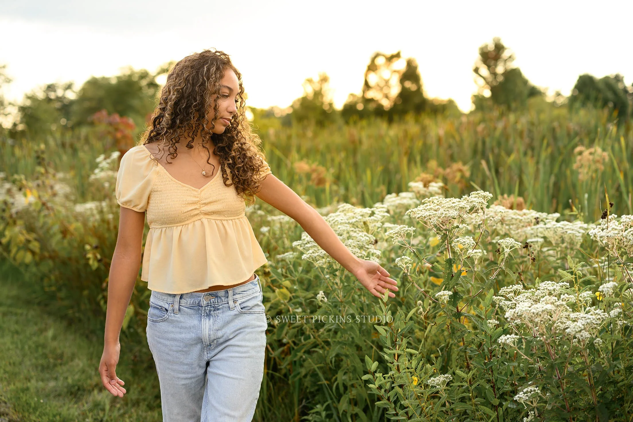 Madeline | Indiana Floral Senior Girl Photography in  Flower Field for Class of 2027 senior girl posing in yellow top and jeans  by Sweet Pickins Studio senior photographer Amanda Wilson ©