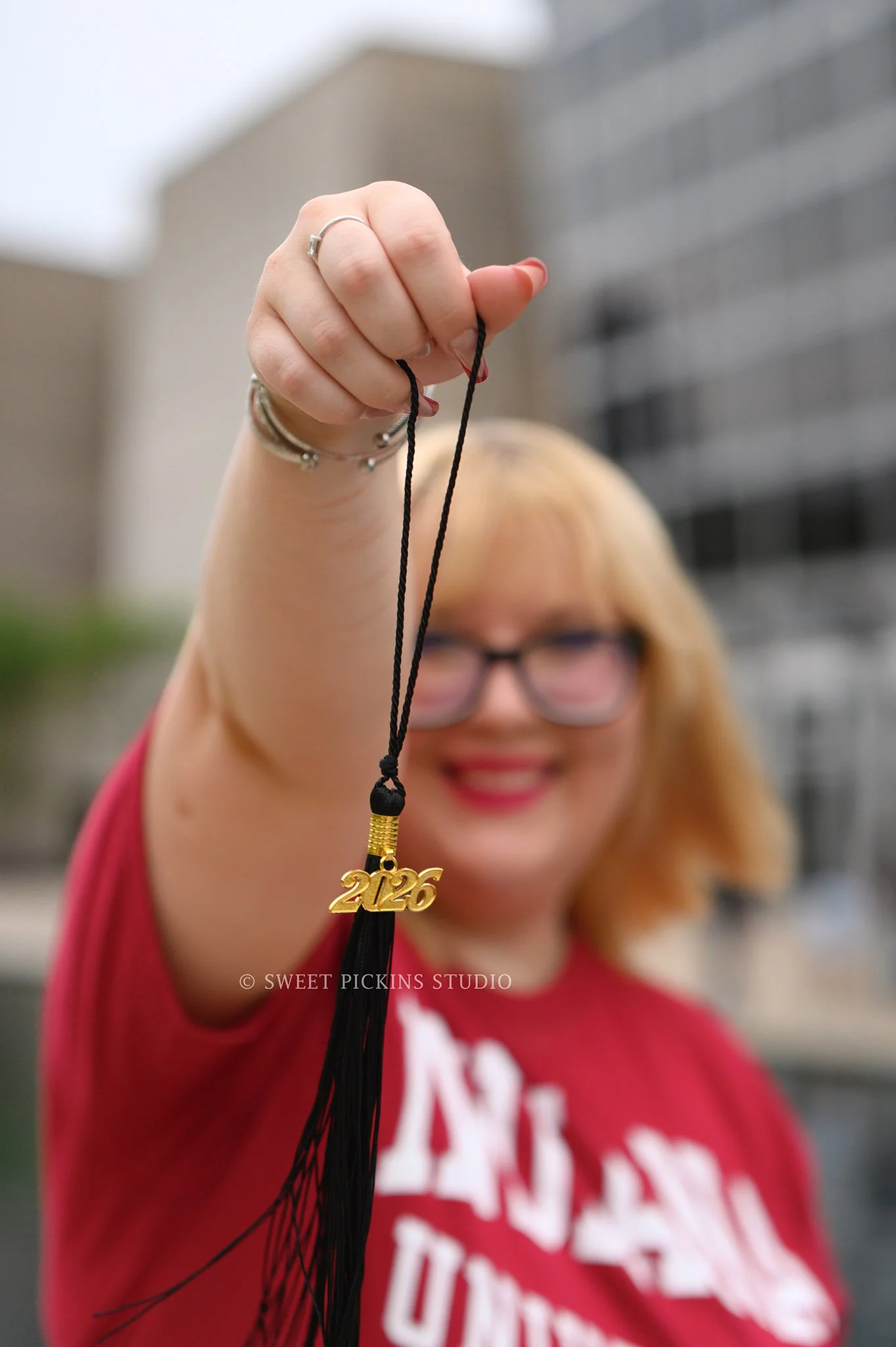 I.U. Indy Graduation Photography in Downtown Indianapolis, Indianafor class of 2026 spring grad wearing red high heels with tassel by Sweet Pickins Studio senior photographer Amanda Wilson ©