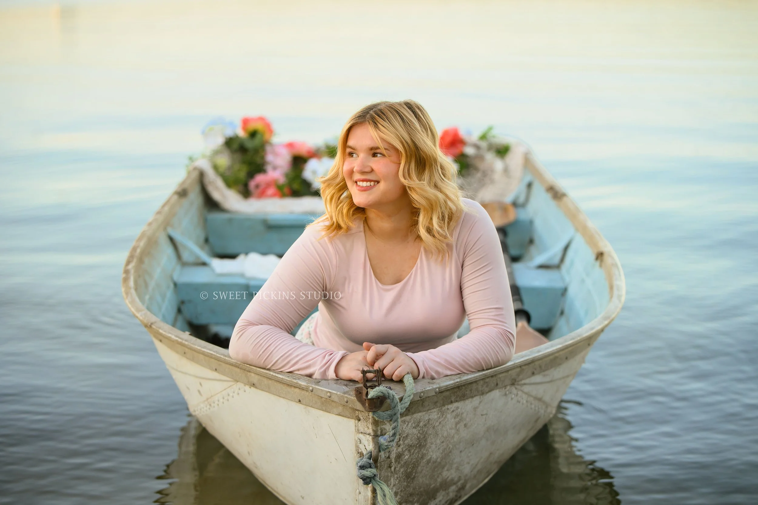 Rilynn’s Peru, Indiana Senior Portrait Photography at the Lake in Boat with flowers for Maconaquah High School class of 2027 senior girl wearing floral skirt by Sweet Pickins Studio senior photographer Amanda Wilson ©