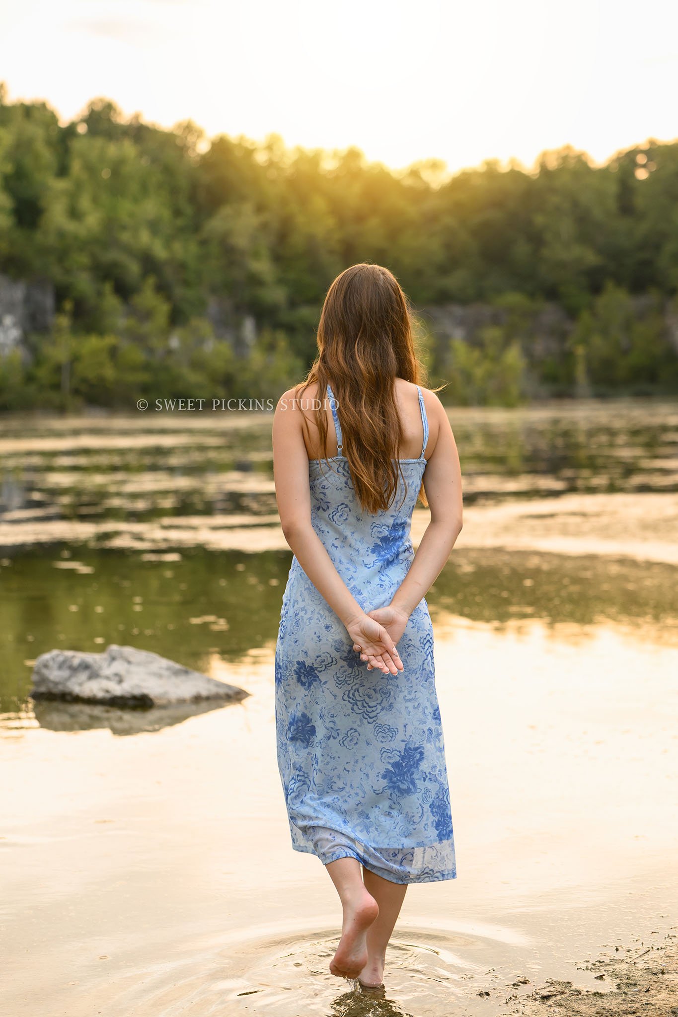 Taylor | Indiana Senior Girl Photography for class of 2027 senior by lake at sunset wearing blue floral dress by Sweet Pickins Studio senior photographer Amanda Wilson ©