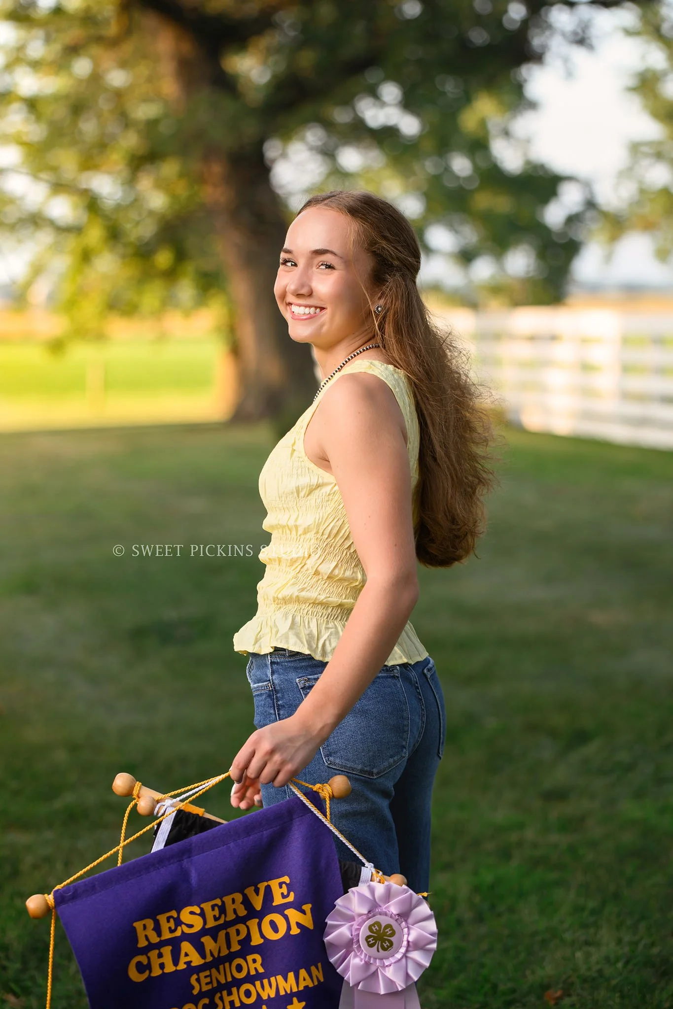 Natalie’s Lowell, Indiana 4-H Senior Photography for class of 2027 senior girl posing with livestock show banners at family farm by Sweet Pickins Studio senior photographer Amanda Wilson ©